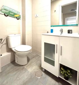 a bathroom with a toilet and a sink and a mirror at Plaza Circular Más que apartamentos in Murcia