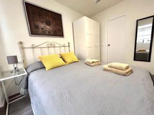 una camera da letto con un letto con cuscini gialli di Plaza Circular Más que apartamentos a Murcia