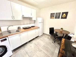 a kitchen with a sink and a table in a room at Plaza Circular Más que apartamentos in Murcia