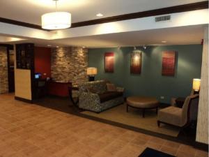 a lobby with a waiting room with a couch and chairs at Holiday Inn Express Hotel & Suites Chicago-Algonquin, an IHG Hotel in Algonquin