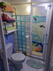 baño con aseo y un mural de pescado en Habitación privada en Casa compartida, 4 adultos, en Ciudad de México
