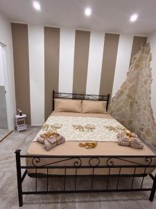 uma cama num quarto com uma parede listrada em Al piccolo borgo em Catânia