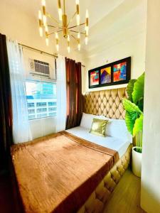 a bedroom with a large bed with a large window at Alabang condo near Bellevue Hotel Filinvest City in Manila