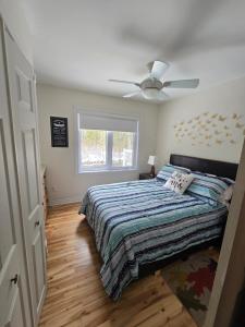 a bedroom with a bed and a ceiling fan at CITQ 303469.CHALET OASIS DE PAIX. BORD DE L’EAU.4 SAISONS.À LOUER in Chertsey