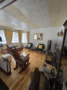 a living room with chairs and a couch and a tv at CITQ 303469.CHALET OASIS DE PAIX. BORD DE L’EAU.4 SAISONS.À LOUER in Chertsey