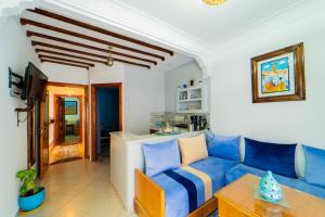 a living room with a blue couch and a kitchen at Dar Jinane in Chefchaouen
