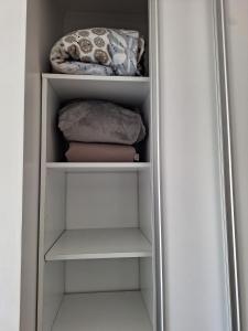 a closet with white shelves and towels at Edificio Charlotte (zona centro) in Posadas +5 photos