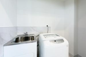 a sink and a washing machine in a bathroom at Modern 3-bds townhouse in South Auckland in Auckland