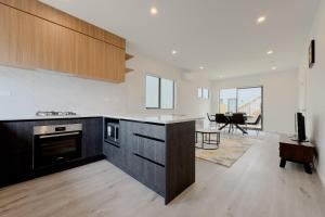 a kitchen with a counter and a living room at Modern 3-bds townhouse in South Auckland in Auckland