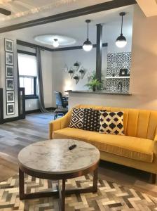 ein Wohnzimmer mit einem gelben Sofa und einem Tisch in der Unterkunft Studio Mins to Forest Park Soulard in Tower Grove