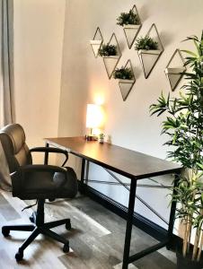 ein Büro mit einem Schreibtisch, einem Stuhl und Pflanzen in der Unterkunft Studio Mins to Forest Park Soulard in Tower Grove