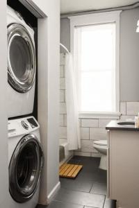 a bathroom with a washer and a washing machine in it at Spacious 3 BR Apt In CWE in Clayton