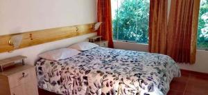 um quarto com uma cama e duas janelas em Eden Lodge em Cabanaconde