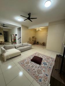 ein Wohnzimmer mit einem Sofa und einem Deckenventilator in der Unterkunft DAHLIA LOVELY HOME in Jitra