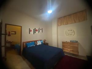 a bedroom with a blue bed and a wooden dresser at Hotel MAHAI in Olón