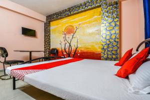 a bedroom with a bed with a painting on the wall at OYO Hotel River View in Patna