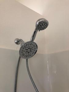 a shower with a shower head in a bathroom at Seagrass Cottage at Beverly Beach in Newport