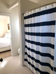 a bathroom with a blue and white shower curtain at Seagrass Cottage at Beverly Beach in Newport