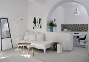 een witte woonkamer met een bank en een tafel bij Bellonias Villas in Kamari