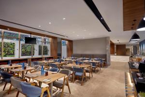 a dining room with wooden tables and chairs at Holiday Inn Express Bengaluru Bommasandra by IHG in Bengaluru
