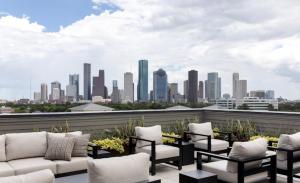 a rooftop patio with chairs and a city skyline at Don's Palace in Houston