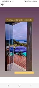 Bild einer offenen Tür zu einem Deck mit einem Regenschirm in der Unterkunft Suítes mirante corumbê in Paraty
