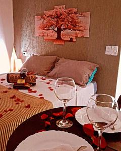 Suítes mirante corumbê في باراتي: غرفة بها طاولة مع كؤوس للنبيذ