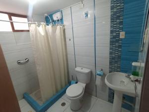 een badkamer met een toilet, een douche en een wastafel bij Siéntete como en casa in Ilo