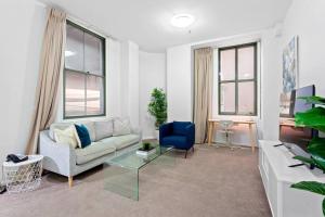 a living room with a couch and a blue chair at Inner City Retreat 1BD Pyrmont - 302 in Sydney