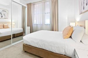 a bedroom with two beds and a mirror at Inner City Retreat 1BD Pyrmont - 302 in Sydney