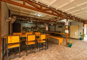 un restaurante con mesas de madera y sillas en una habitación en Arenal Sloth Hostel, en Fortuna