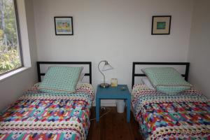 1 Schlafzimmer mit 2 Betten und einem blauen Tisch in der Unterkunft Melaleuca in Manyana