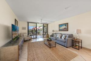 a living room with a couch and a tv at Kamaole Sands 7307 in Wailea