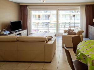 ein Wohnzimmer mit einem Sofa und einem TV in der Unterkunft Helios 0201 with central location in Nieuwpoort