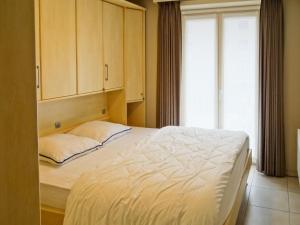 Schlafzimmer mit einem Bett, einem Schrank und einem Fenster in der Unterkunft Helios 0201 with central location in Nieuwpoort