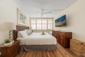 a bedroom with a large white bed and a window at Kamaole Sands 7307 in Wailea