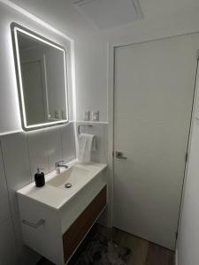 Ua - Apartamento Moderno في غواتيمالا: حمام أبيض مع حوض ومرآة