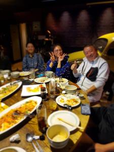 un grupo de personas sentadas en una mesa comiendo comida en Mt, Iwate Motorlodge OLDWOOD - Vacation STAY 20528v, en Hachimantai