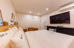 a bedroom with a bed and a flat screen tv at The First Boutique Hotel in Gwangju