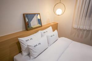光州The First Boutique Hotel的卧室配有带枕头和镜子的白色床