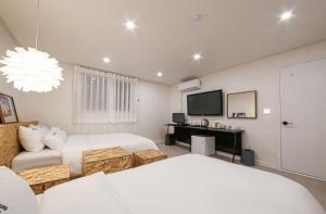 a bedroom with a bed and a couch and a tv at The First Boutique Hotel in Gwangju