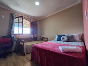 a bedroom with a bed with a red blanket at Casa do sossego in Cabo Frio +58 photos
