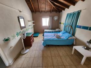 1 dormitorio con 2 camas y suelo de madera en Saona Típica B&B en Mano Juan