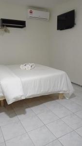 - un lit avec un drap blanc au-dessus dans l'établissement Mjc New township 6BR by Natol Homestay-MJC, à Kuching