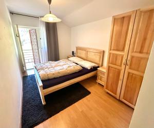 - une chambre avec un lit et une armoire en bois dans l'établissement Canj Family Resort, à Čanj