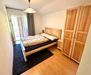 ein Schlafzimmer mit einem Bett und einem Holzschrank in der Unterkunft Canj Family Resort in Čanj