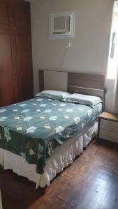 een slaapkamer met een bed met een groen dekbed bij Let it be in Vitória