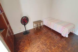 a bedroom with a bed and a floor fan at Let it be in Vitória