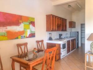 een keuken met een eettafel en een schilderij aan de muur bij Bel Air/Sutton in San Juan del Sur