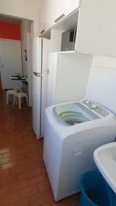 een wasmachine in een kamer met een koelkast bij Let it be in Vitória